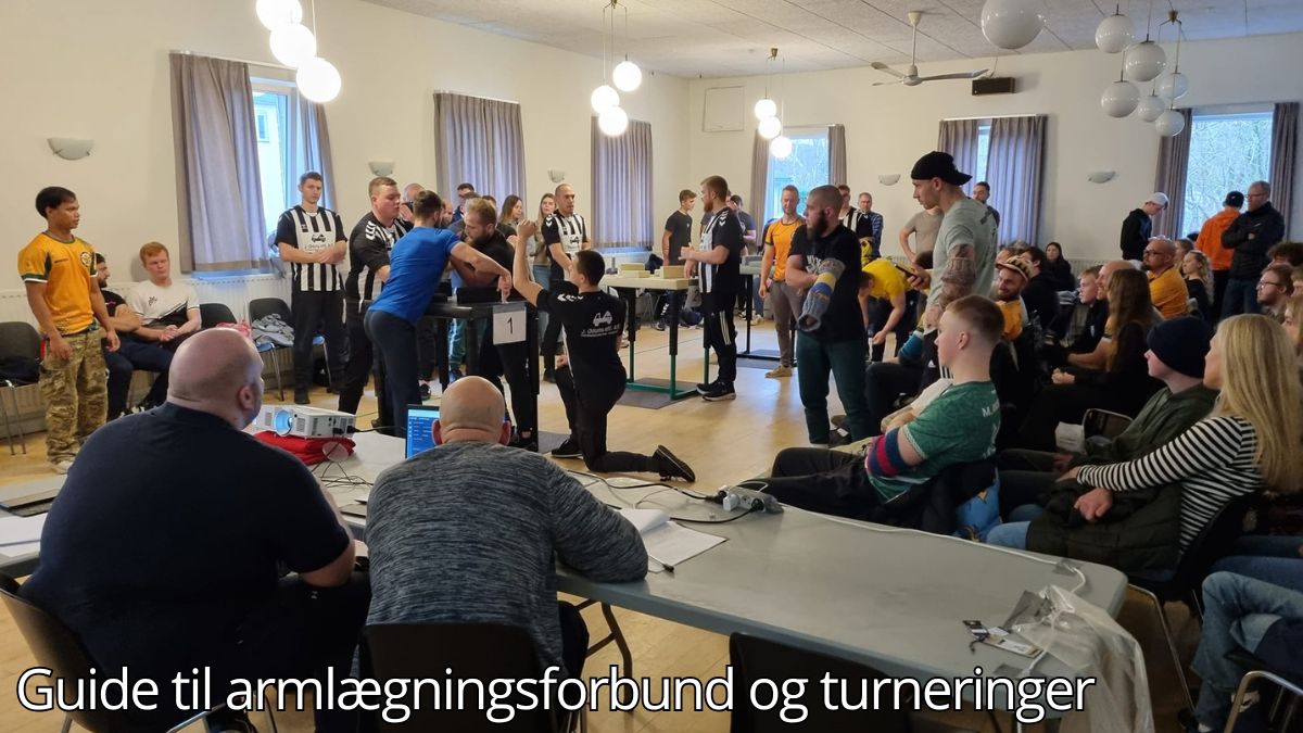 Billedet viser en armlægningsturnering i en stor sal. Flere deltagere konkurrerer ved armlægningsborde, mens dommere og tilskuere overvåger kampen. I forgrunden sidder officials ved et bord med computerudstyr og papirer, der administrerer turneringen. Stemningen er fokuseret med både publikum og deltagere engageret i sporten. Billedetekst: "Guide til armlægningsforbund og turneringer''